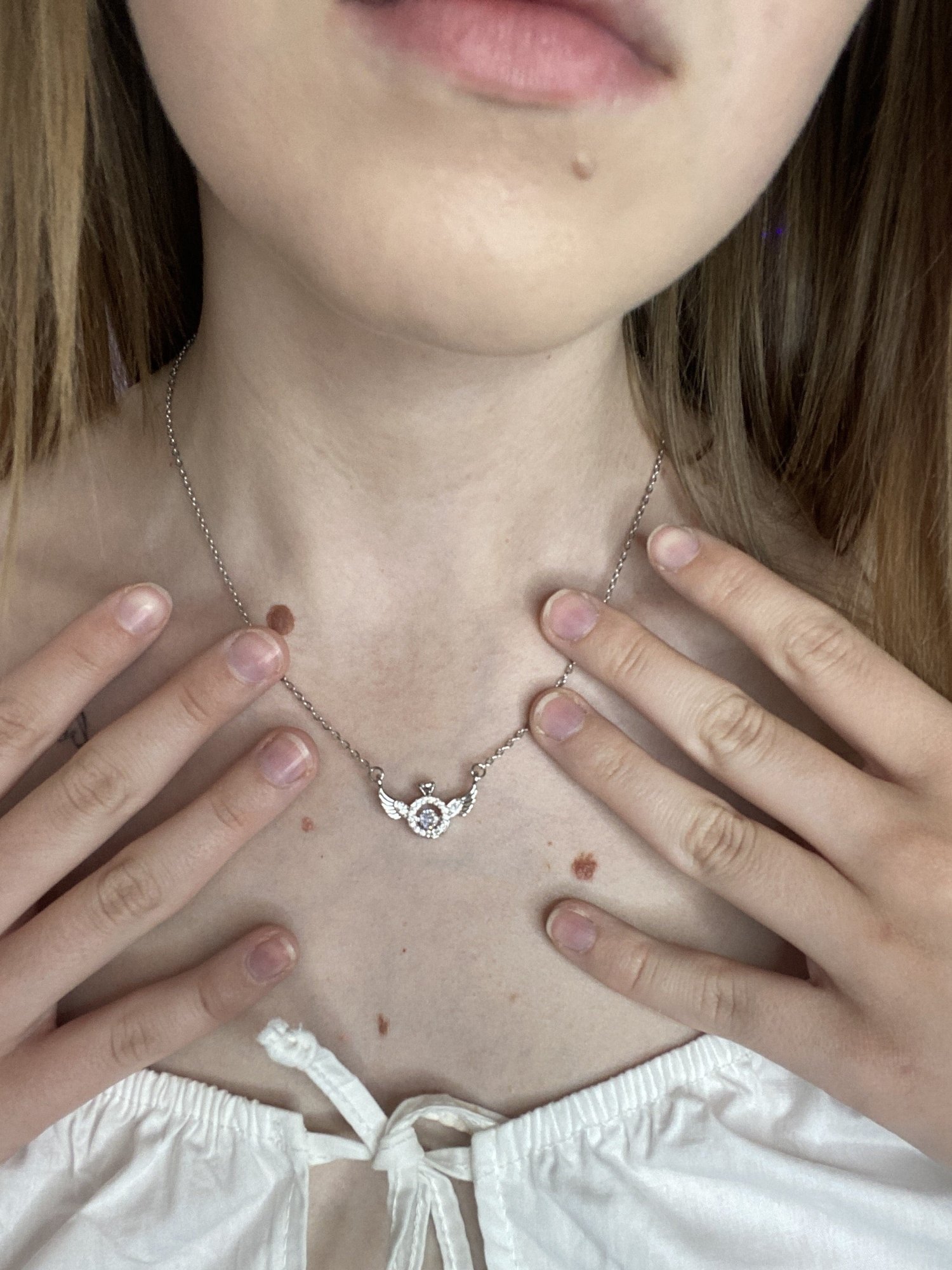 The angel wing necklace worn at the collarbone