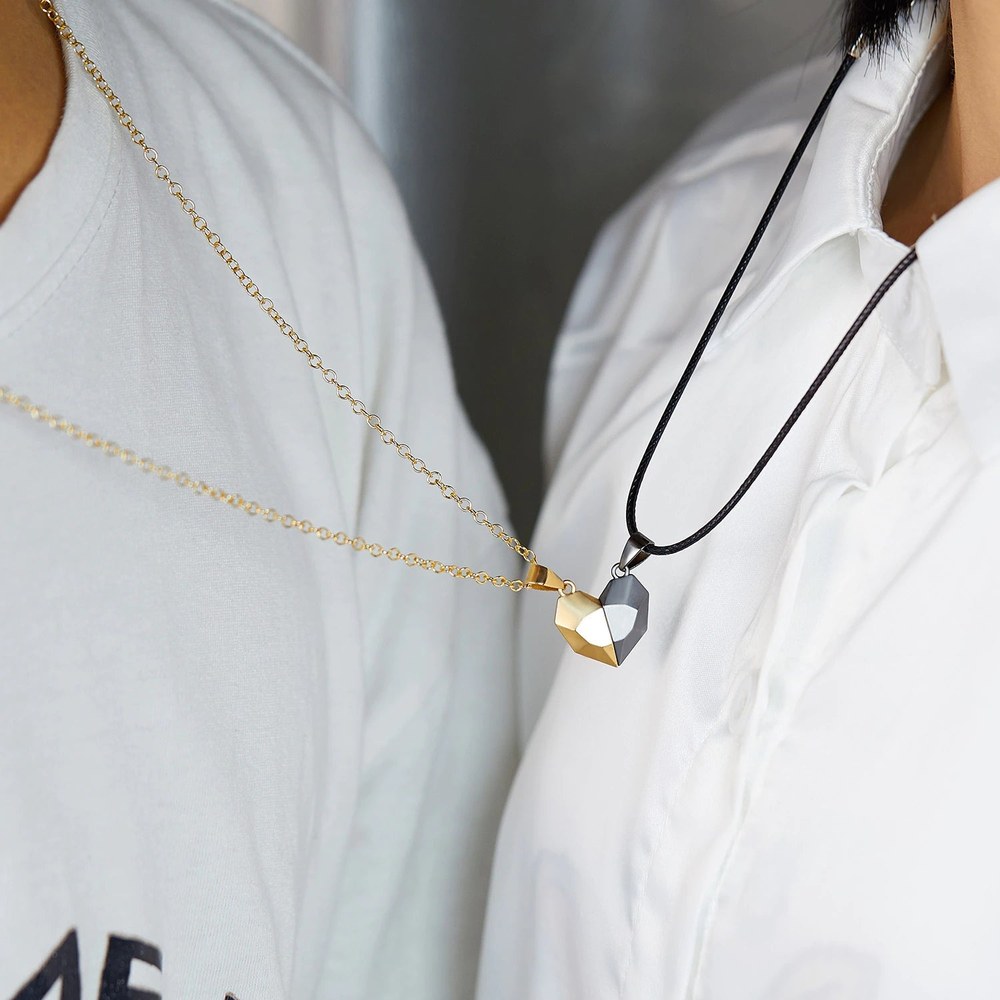 Two people wearing the magnetic heart necklaces